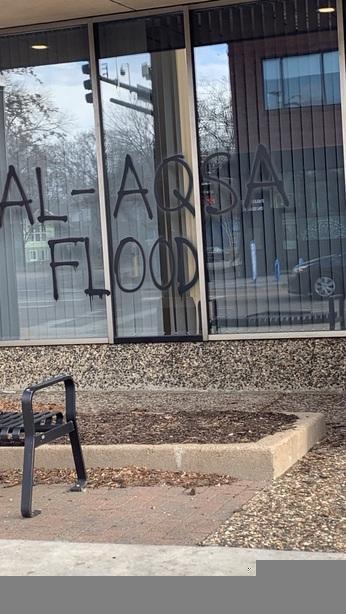 A bank window has "Al-Aqsa Flood" written on it with black spraypaint.