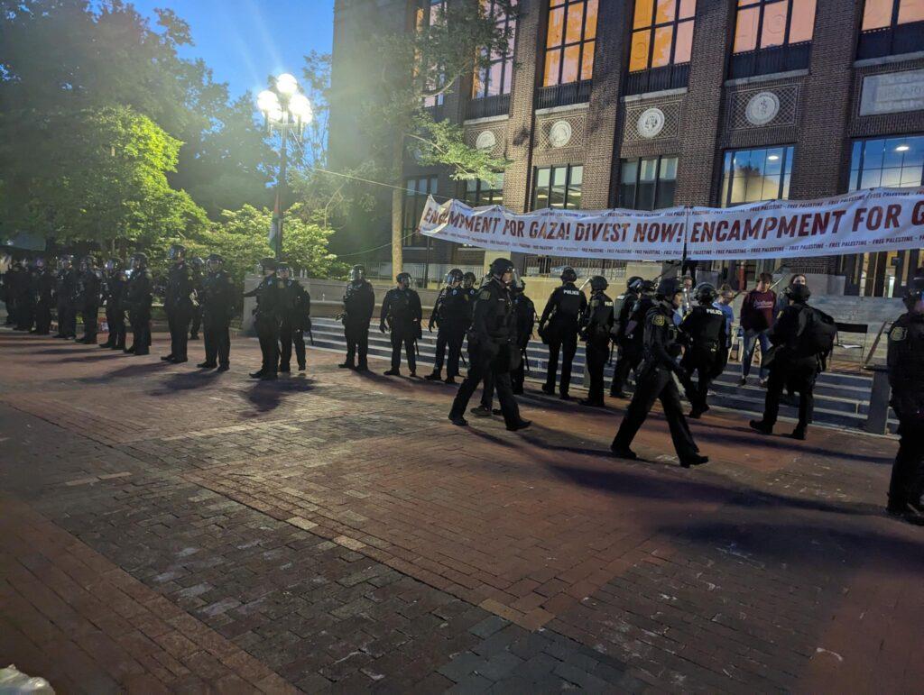 A line of UMPD officers in riot gear prepare to violently sweep the Palestine solidarity encampment at the University of Michigan